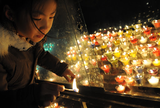 A South Korean girl lights candles at Myeongdong Catholic Cathedral in Seoul &#8211; en