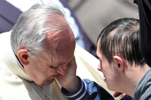 A down&#8217;s syndrome boy caresses Pope Francis &#8211; en