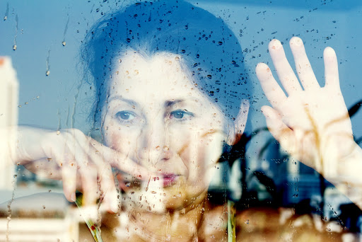 Hands of a sad woman in front of a window &#8211; en