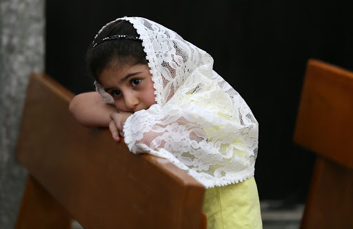 Christian child prays in Church in Iraq