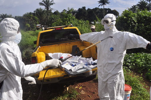 Healthcare workers in Liberia disinfect each other after Ebola exposure