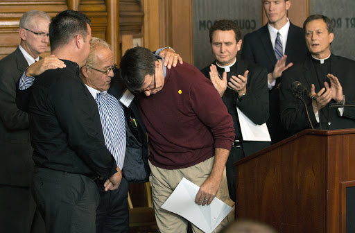 Attorney Jeff Anderson gives a hug to abuse survivors