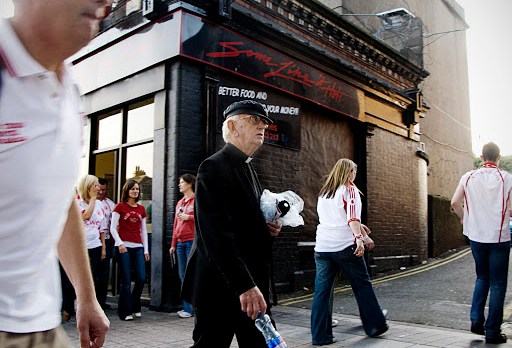 priest in front of pub