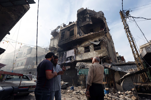 Men stand near war-damaged building in Tripoli, Lebanon