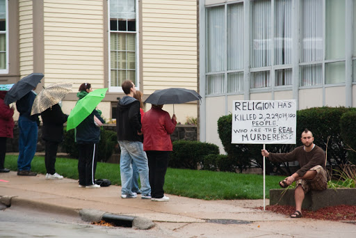 Pro-lifers demonstrate while pro-abort holds sign