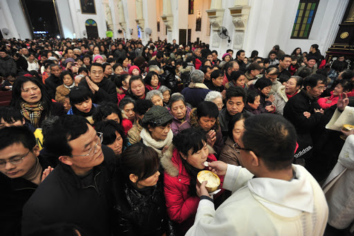 Chinese worshippers receive the Eucharist from a priest &#8211; en