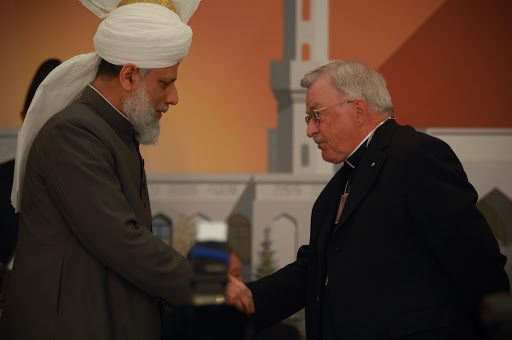 Bishop Fred Henry shakes hands with HH Mirza Masroor Ahmad
