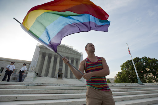 Gay rights advocate waves rainbow flag in front of US Supreme Court