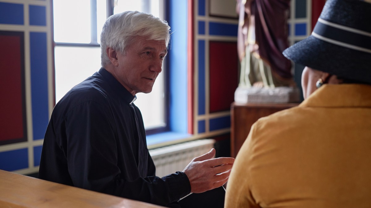Woman talks with priest