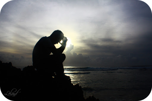 Man praying at oceanside