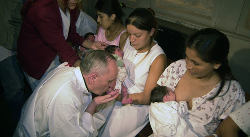 Pope Francis kisses feet of an infant