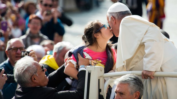 Pope Francis gets a kiss by a young girl