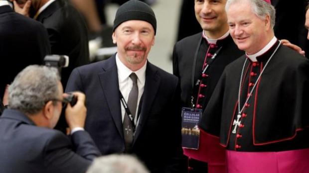 U2 guitarist David Evans, also known by his stage name The Edge, poses with Irish bishop Paul Tighe before listening to U.S. Vice President Joe Biden in Paul VI hall at the Vatican