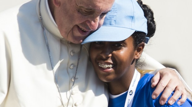 Pope Francis embraces a girl
