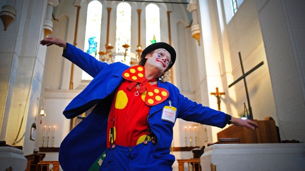 A clown is pictured in front of the altar