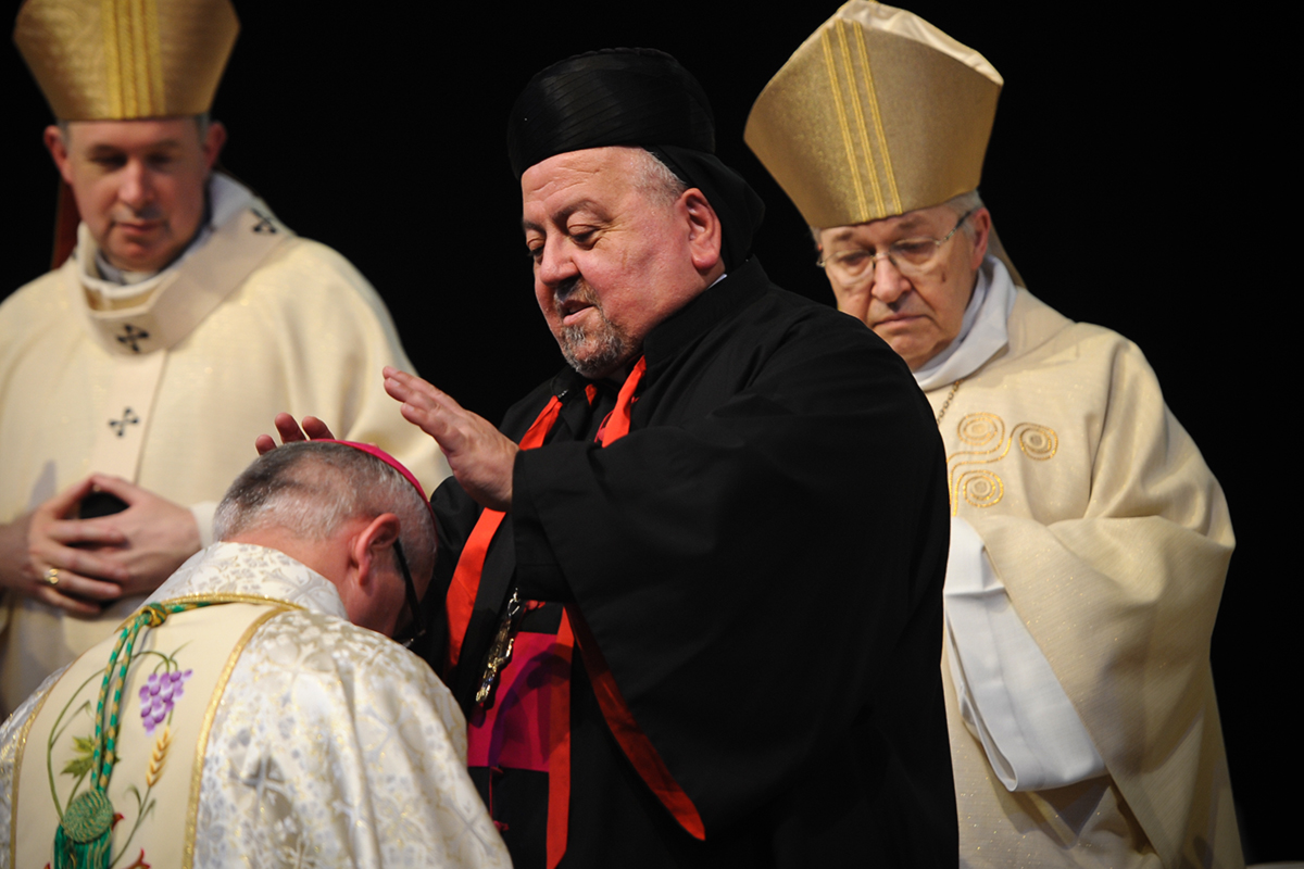 Maronite bishop of Damas Samir Nassar (C) places his hands on the head of newly elevated Bishop Georges Colomb (L) during his episcopal ordination next to the Archbishop of Paris Mgr Andre Armand Vingt-Trois (R) on May 5, 2016 at the Parc des expositions in La Rochelle, western France.  