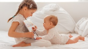 web-children-infant-sister-reading-book-shutterstock_440300512