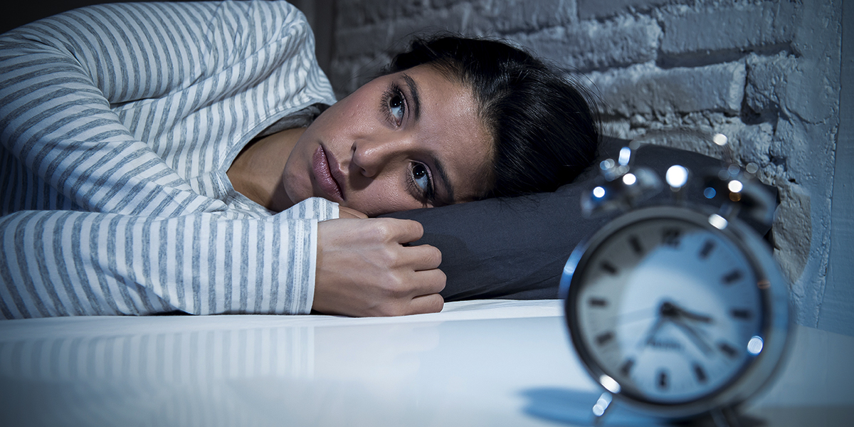WEB-YOUNG-WOMAN-INSOMNIA-CLOCK-BED-LOOKING-UP-Marcos-Mesa-Sam-Wordley-Shutterstock_530558287