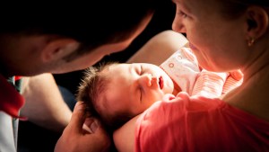 Happy parents holding their newborn baby girl