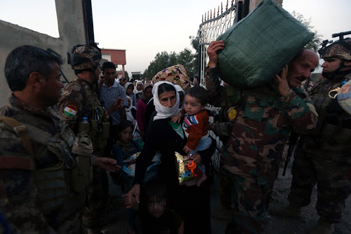 Kurdish Peshmerga forces help people from Iraq&#8217;s Yazidi minority as they arrive at a medical center in the town of Altun Kupri &#8211; AFP &#8211; fr