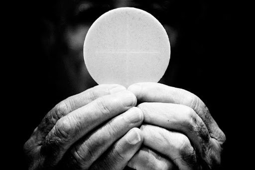 A priest holds eucharist &#8211; fr
