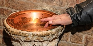 Why do Catholics bless themselves with holy water when entering a church?