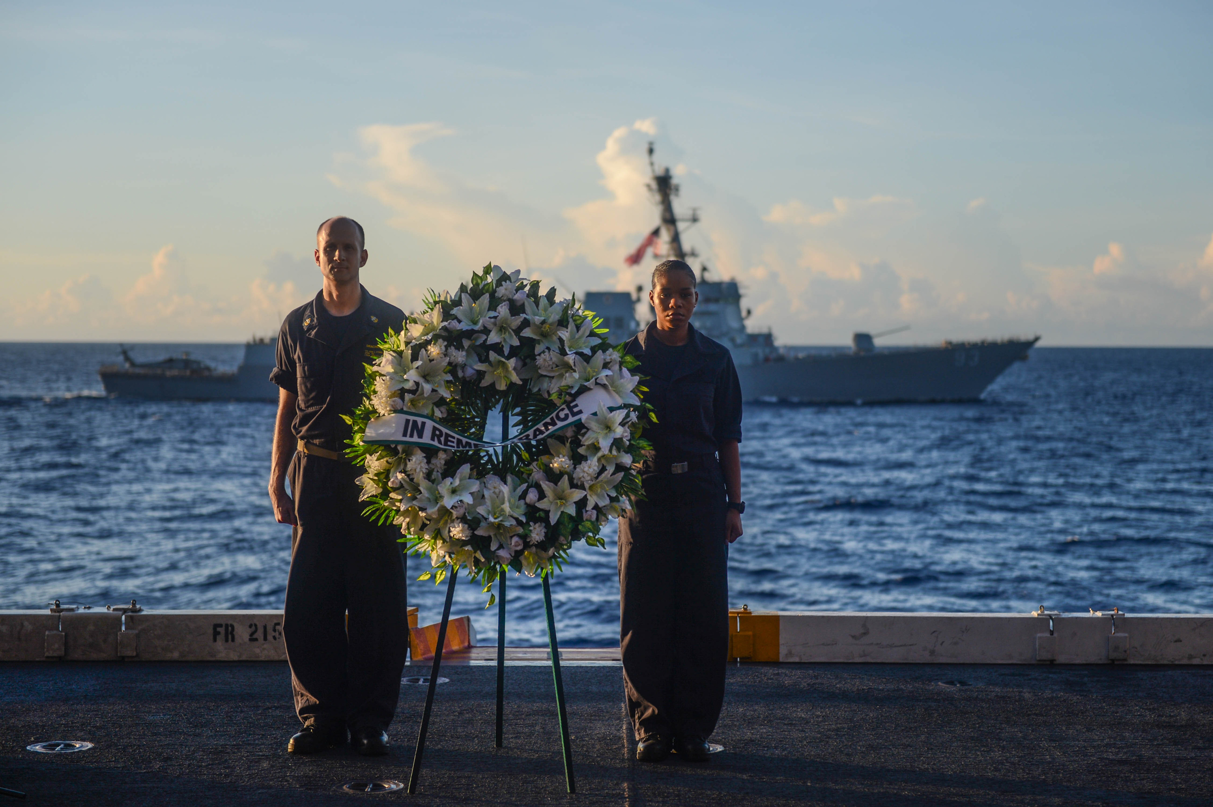 Sailors stand at attention during a wreath-laying ceremony on US