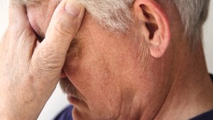 GRIEVING MAN,HANDS OVER FACE