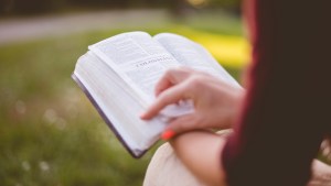 WOMAN,READING BIBLE,OUTSIDE