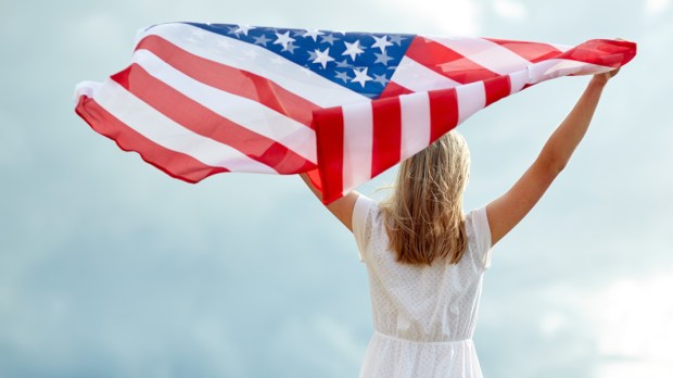 WEB3 WOMAN SKY AMERICAN FLAG US PATRIOTIC Shutterstock