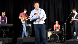 MAN WITH BIBLE PREACHING ON STAGE