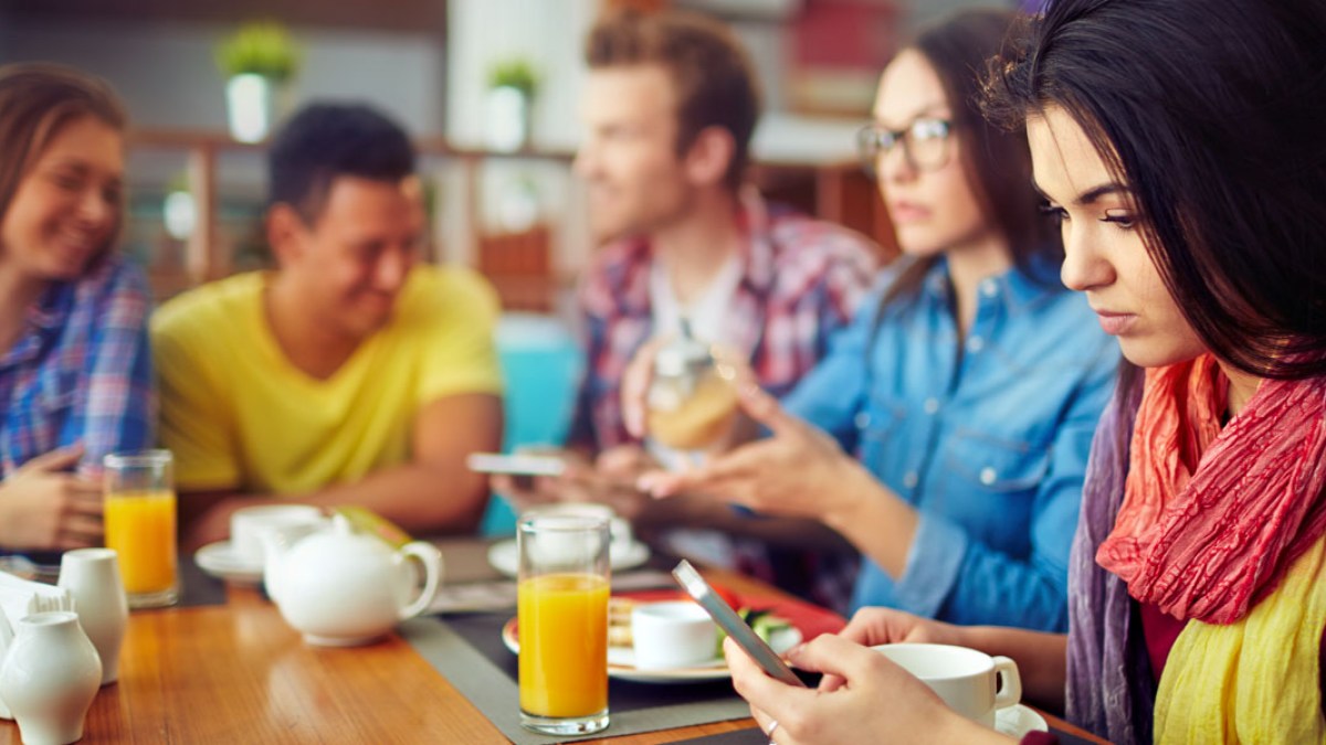 WEB3 FRIENDS DINNER RESTAURANT PHONE WOMAN SMARTPHONE EMAIL TEXT Shutterstock
