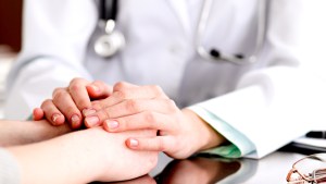 DOCTOR HOLDING PATIENTS HANDS