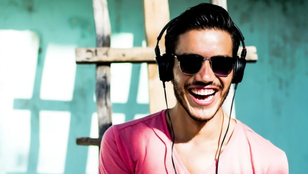 MAN LISTENING OT HEADPHONES