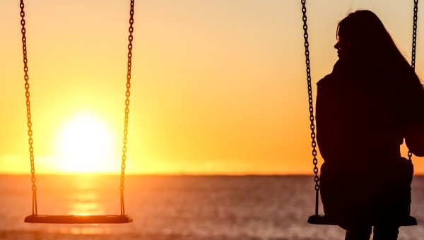 WOMAN SITTING ON SWING,ALONE