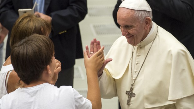 Pope Francis shakes hands with a believer