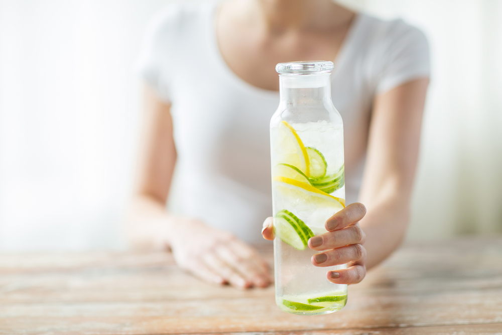 WEB-WOMAN-LEMON-JUICE-TABLE-BOTTLE-shutterstock_281445404-By Syda Productions-AI