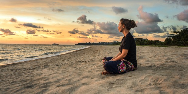 WOMAN SITTING ON BEACH