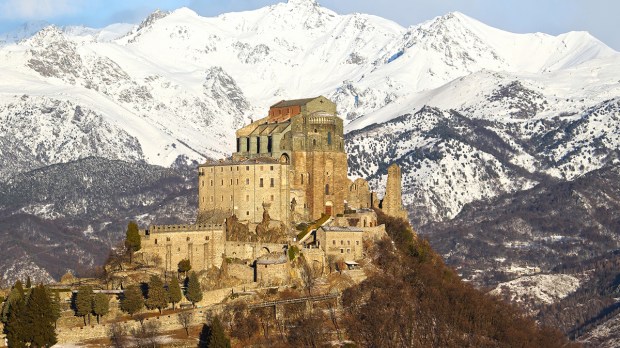 WEB &#8211; CUP001 &#8211; The Sacra di San Michele, the symbol of the Italian region of Piedmont, stands in the dawn. In the background are visible mountains of the Val di Susa &#8211; shutterstock_640285153