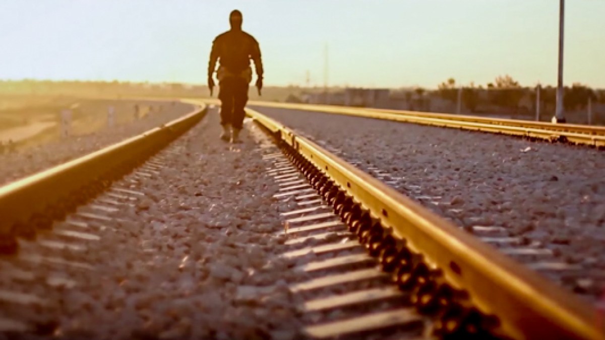 MAN WALKING ON TRACKS