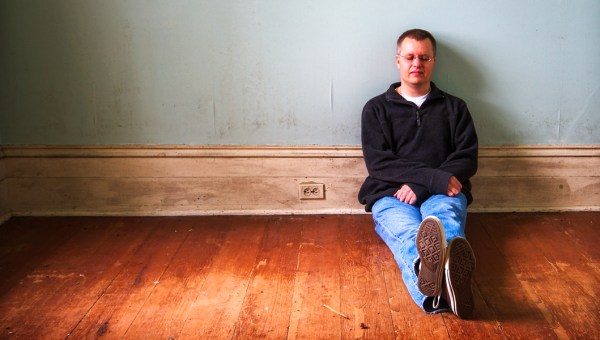 MAN SITTING ON FLOOR