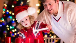 LITTEL GIRL WITH DAD,LIGHTING CANDLE