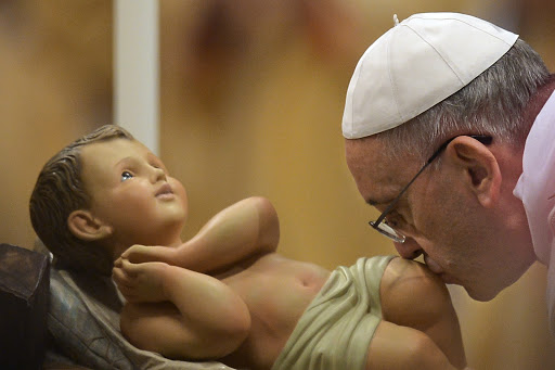 Pope Francis kisses the unveiled baby Jesus during a Christmas Eve mass at St Peter&#8217;s Basilica &#8211; pt