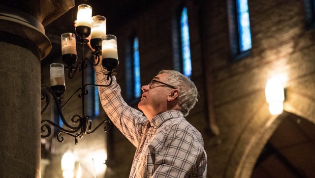 MAN LIGHTING CHURCH CANDLES