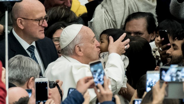 Pope Francis kisses a child