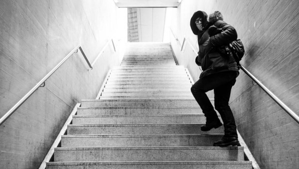 WOMAN WALKING UPSTAIRS LOOKING BACK