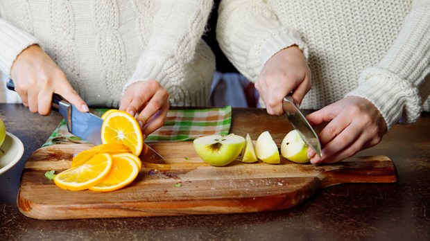 WOMEN SLICING FRUIT