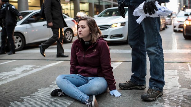 WOMAN SITTING IN THE MIDDLE OFTHE STREET