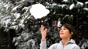 WOMAN TOSSING SNOWBALL