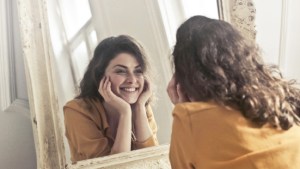 WOMAN LOOKING INTO MIRROR